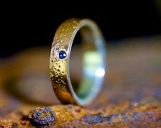 a close up of a ring on top of a piece of wood with water droplets