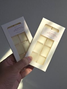 a hand holding an open box of white chocolate