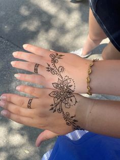 two hands with henna tattoos on them