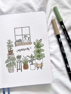 an open notebook with plants on it next to two markers and pencils in front of them