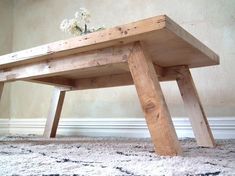 a small wooden table sitting on top of a carpeted floor next to a wall