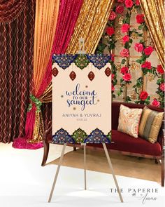 a welcome sign is displayed in front of curtains and flowers on display at the reception