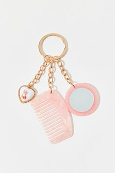 a pink comb and mirror keychain on a white background