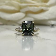 "Radiant Cut Olive Green Sapphire Engagement Ring 14K White Gold Unique Vintage Olive Green Sapphire Engagement Rings Green Sapphire Ring  For more olive green options click her:  https://etsy.me/3Lb9ghd To re-visit our store click here: https://etsy.me/3Pzzwpx For olive green necklaces click here: https://etsy.me/44dSDJo The ring pictured is lab created olive green sapphire with moissanite accents #7246 This ring can be made with many different stone colors Message us for pricing on different c Engagement Rings Green, Green Engagement Rings, Rings Green, Green Sapphire Engagement, Green Sapphire Engagement Ring, Sapphire Engagement Rings, Green Sapphire Ring, Sapphire Engagement Ring, Green Sapphire