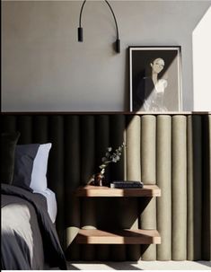 a bedroom with a bed, nightstand and side table in front of a window that has vertical blinds on the wall