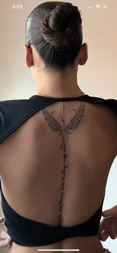 the back of a woman's body with tattoos on her upper and lower back