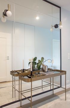 a desk with a mirror and some plants on it