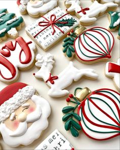 decorated christmas cookies with santa claus and other holiday treats on a white tablecloth background