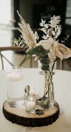 a vase with flowers and candles on a table