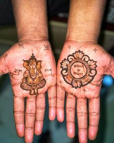 two hands that have tattoos on them with the words om shanti and ganesh