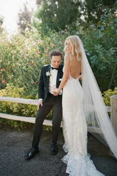 a bride and groom sitting on a bench