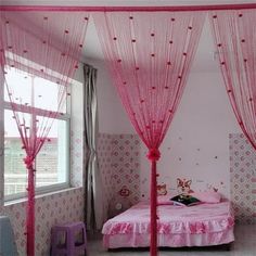 a pink canopy bed in a girls bedroom