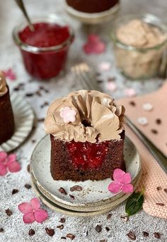 a piece of chocolate cake on a plate with whipped cream and cherries around it