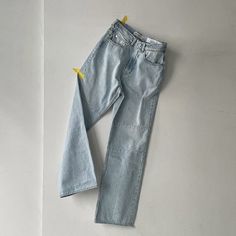 a pair of blue jeans laying on top of a white wall