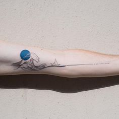 a man's arm with a tattoo on it and a blue ball in the middle