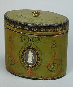 an old green box with a woman's silhouette on it and gold trim around the lid