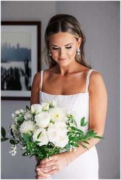 a woman holding a bouquet of white flowers