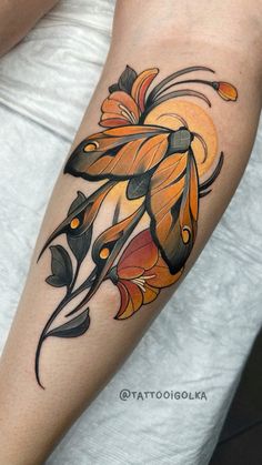 a woman's arm with an orange and black flower tattoo on her left forearm