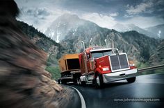 two semi trucks driving down a mountain road