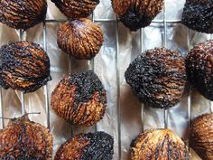 chocolate covered donuts sitting on top of a metal rack