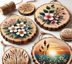 four wood slices with flowers painted on them and twine cord hanging from the ends