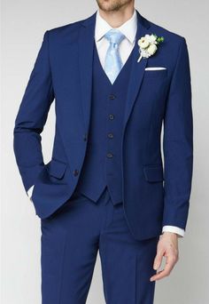 a man in a blue suit with a flower on his lapel