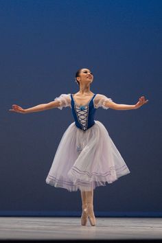 the ballerina is wearing a blue and white dress