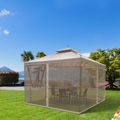 a gazebo in the middle of a lawn with chairs and tables inside on it