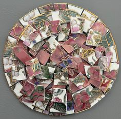 a plate that has some kind of mosaic on top of it with flowers and leaves