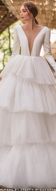 a woman in a white wedding dress is standing outside