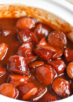 a close up of food in a bowl with sauce on the top and meat inside