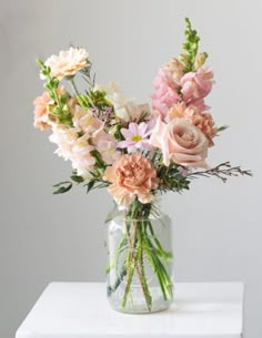 a vase filled with lots of pink and white flowers