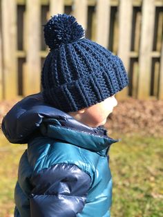 a small child wearing a blue jacket and hat