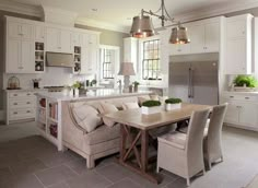 a kitchen filled with lots of white furniture