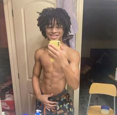 a shirtless man taking a selfie in front of a mirror