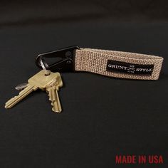 there is a keychain that has some keys in it on the table with a black background