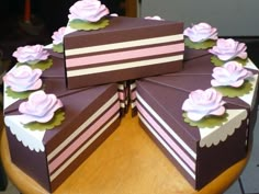 there are four boxes that have flowers on top of each one in the shape of a cake