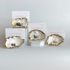 three oysters are on display in front of two business cards and one is gold