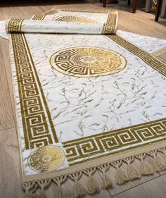 a white rug with gold trim on the floor