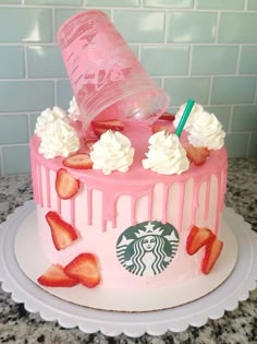 a pink starbucks cake with strawberries and whipped cream