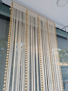 the curtains are hanging in front of the window with beaded trimmings on them