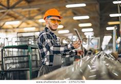 a man in an orange helmet and safety glasses is working at the factory