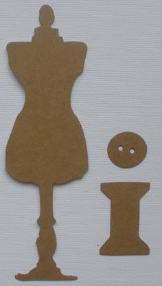 a cutout of a mannequin with buttons and a sewing needle next to it