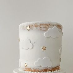 a white cake with gold stars and clouds on it