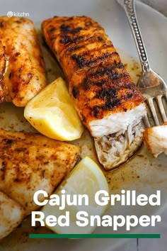 grilled red snapper fish on a plate with lemon wedges and a fork