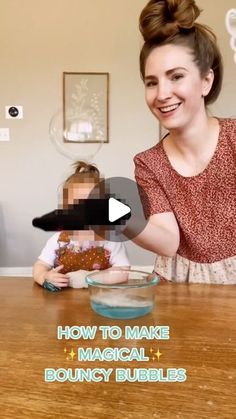 a woman holding a baby in front of a bowl on top of a wooden table