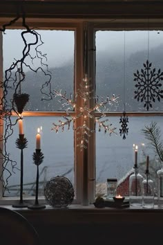 a snowflake sitting on top of a window sill next to a candle