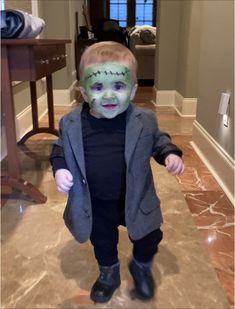 a little boy with green face paint on his face