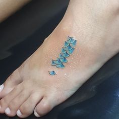 a person has a blue tattoo on their foot