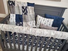 a baby crib with blue and gray bedding